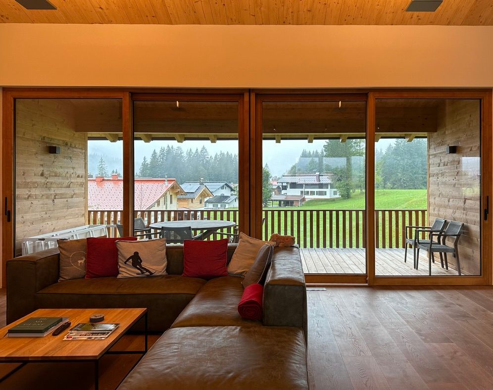 Wohnraum mit Fensterfront und Balkon imm Hintergrund