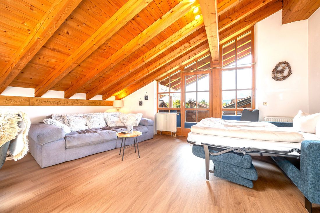 Großer, heller Wohnbereich mit Couch und Schlafsofa (im Bild ausgeklappt)
